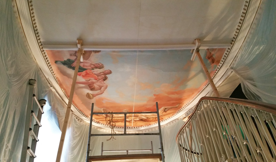 Halfway through the process of installing canvas mural painting on ceiling